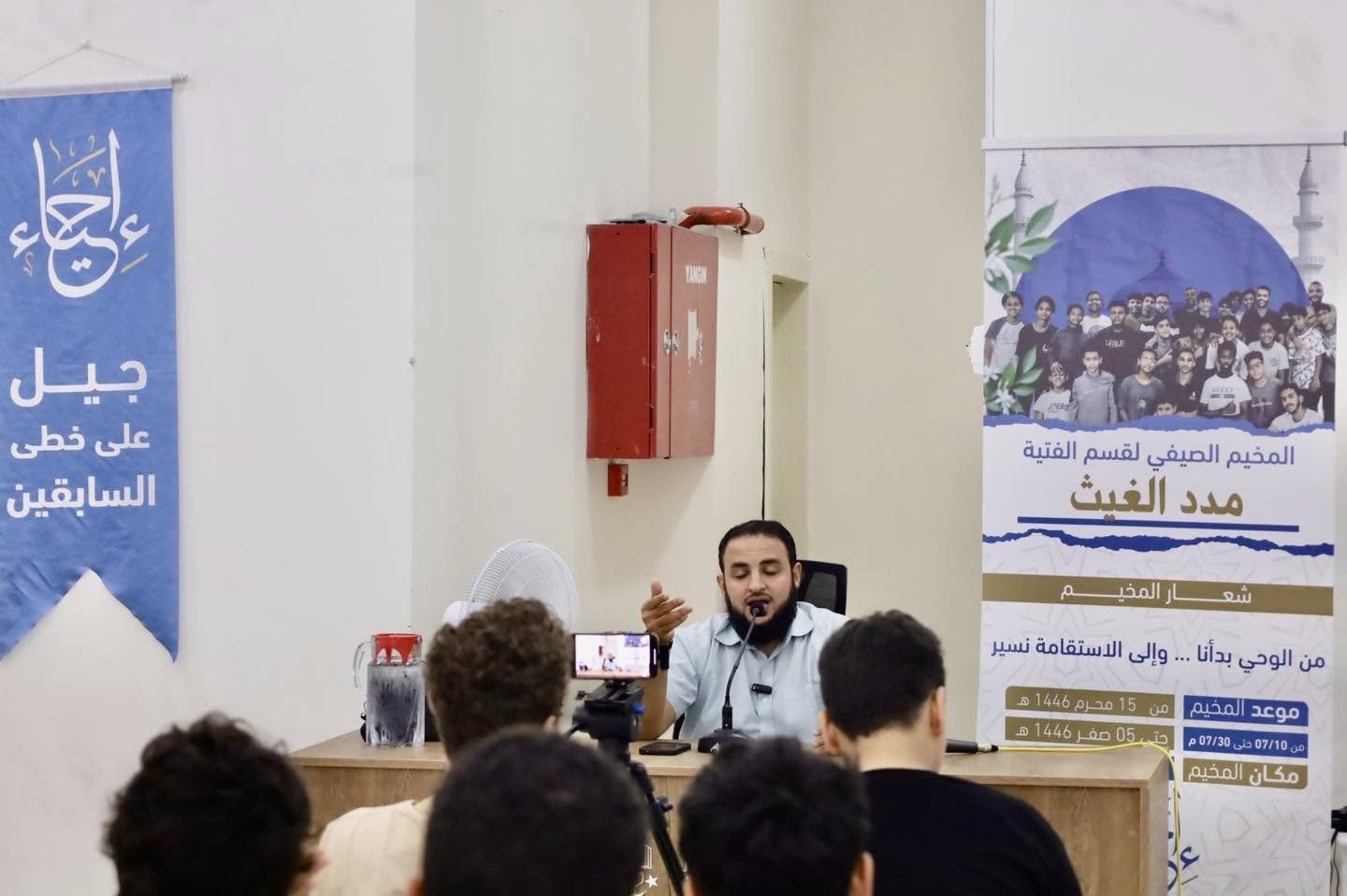 محاضر يتحدث أمام الفتيان في المخيم الصيفي لقسم الفتية