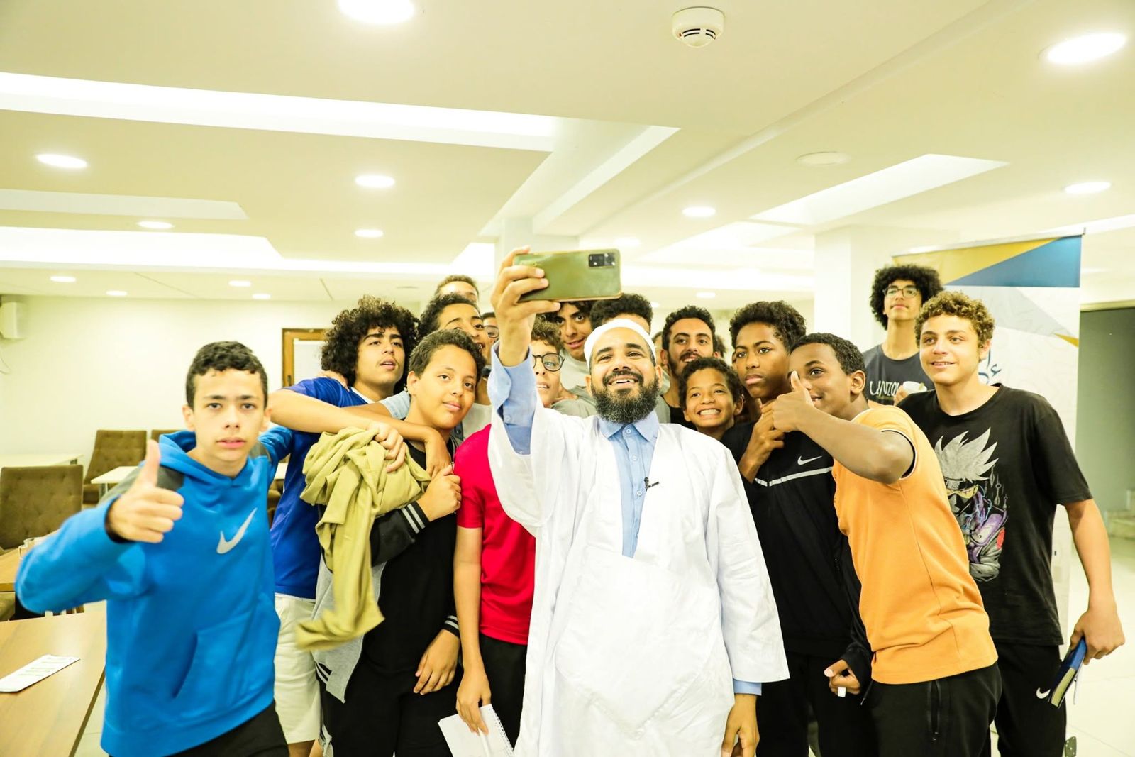 شيخ يلتقط صورة تذكارية مع مجموعة من الفتيان