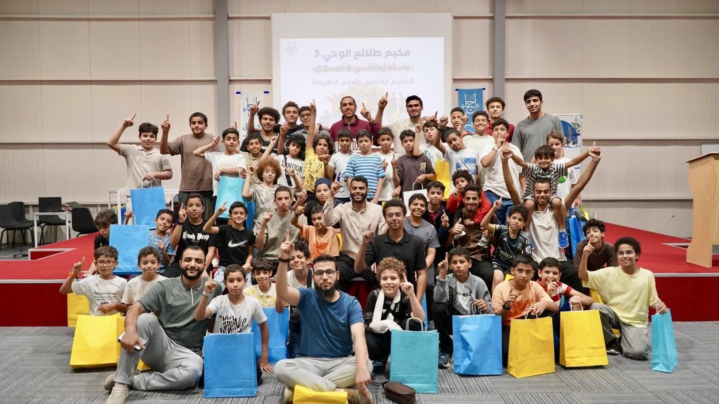 صورة جماعية لفتيان ومشرفين يحملون هدايا في مخيم لمؤسسة إحياء