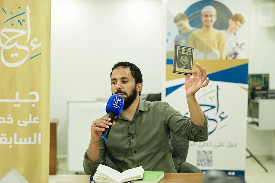محاضر يرفع المصحف خلال درس قرآني